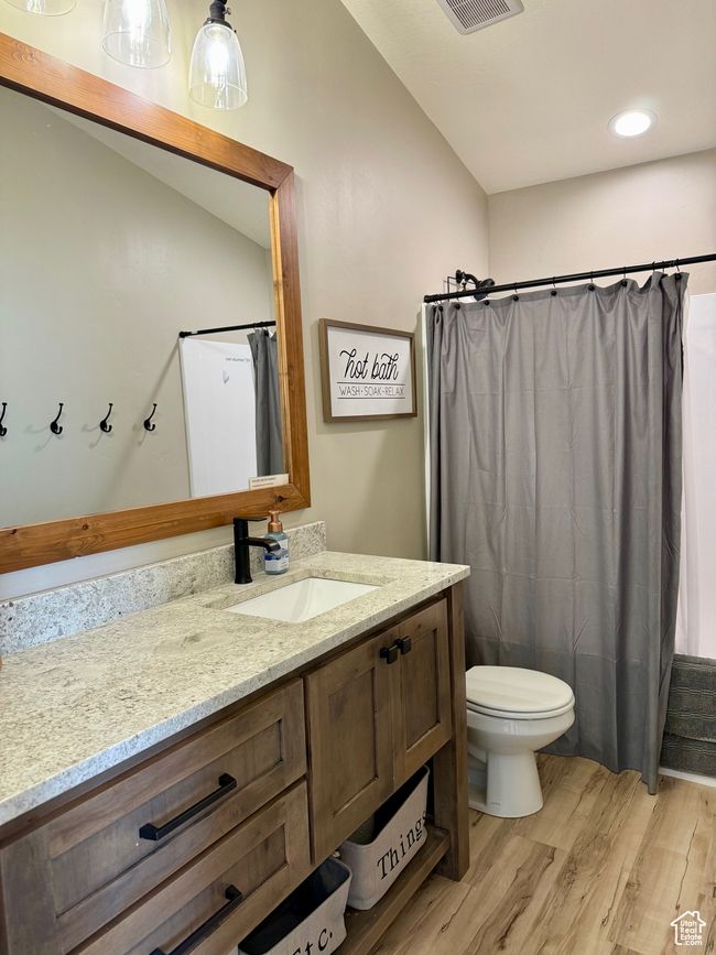 Bathroom with vanity, toilet, a shower with shower curtain, wood finished floors, and visible vents | Image 33