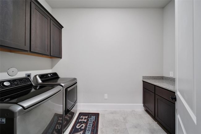 Spacious utility room with built-in cabinetry and plenty of room for full-size washer and dryer. | Image 37