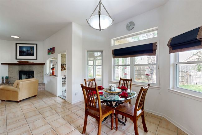 Dining space with a brick fireplace, baseboards, and light tile patterned floors | Image 12