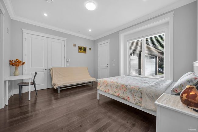 Bedroom with dark wood-style floors, ornamental molding, and recessed lighting | Image 19