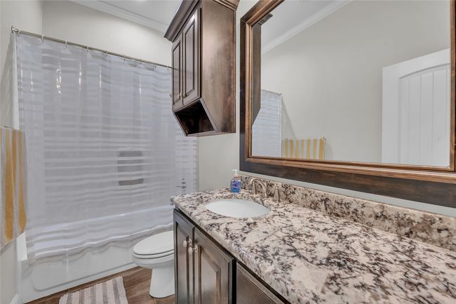 Bathroom featuring ornamental molding, vanity, toilet, shower / tub combo with curtain, and wood finished floors | Image 32