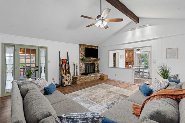 Living area featuring ceiling fan, light wood-style flooring, and a brick fireplace | Image 6