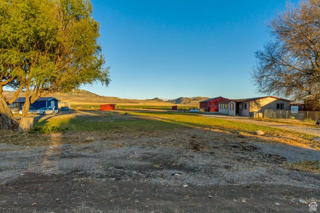 View of yard featuring a mountain view and a view of the log cabin West home, the East home, and the barn in the back | Image 4