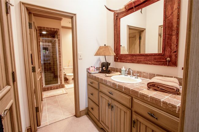 Full bathroom with toilet, vanity, tile patterned floors, and a shower stall | Image 19