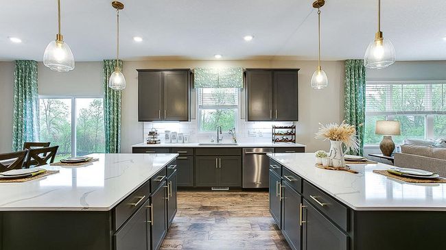 The kitchen is flooded with natural light from the large windows in the family room, kitchen above the sink, and sliding door. | Image 11