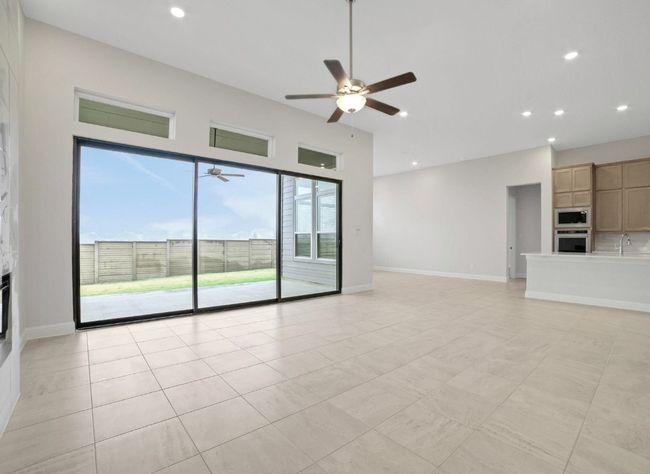 Unfurnished living room featuring ceiling fan, recessed lighting, light tile patterned flooring, a sink, and baseboards | Image 7