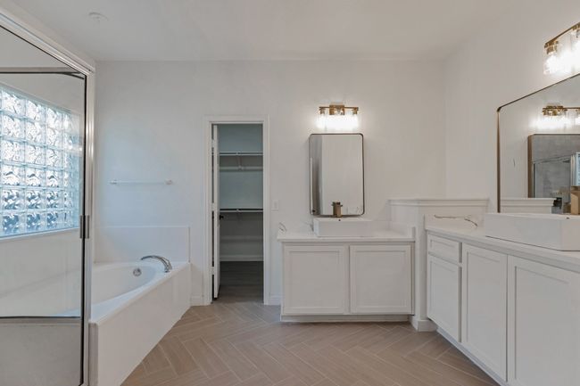 Bathroom with two vanities, a shower stall, a bath, and a spacious closet | Image 16