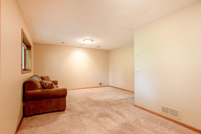 An extended view of the lower-level family room highlights its ample size and neutral palette—ready for your personal touch. | Image 26