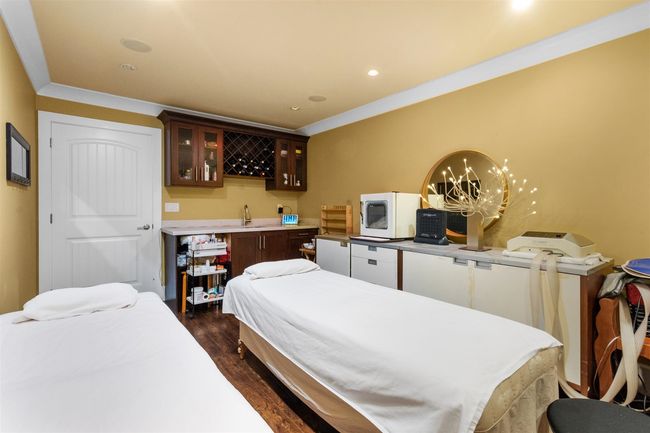 Bedroom with dark wood-style flooring, wet bar, a chandelier, recessed lighting, and fridge | Image 35