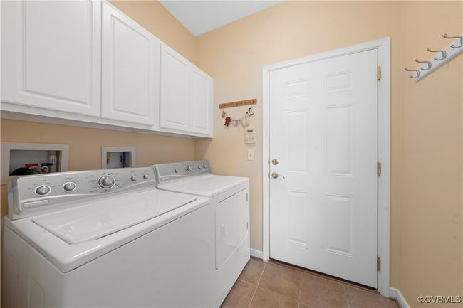Washroom with cabinet space, washing machine and clothes dryer, and light tile patterned floors | Image 22