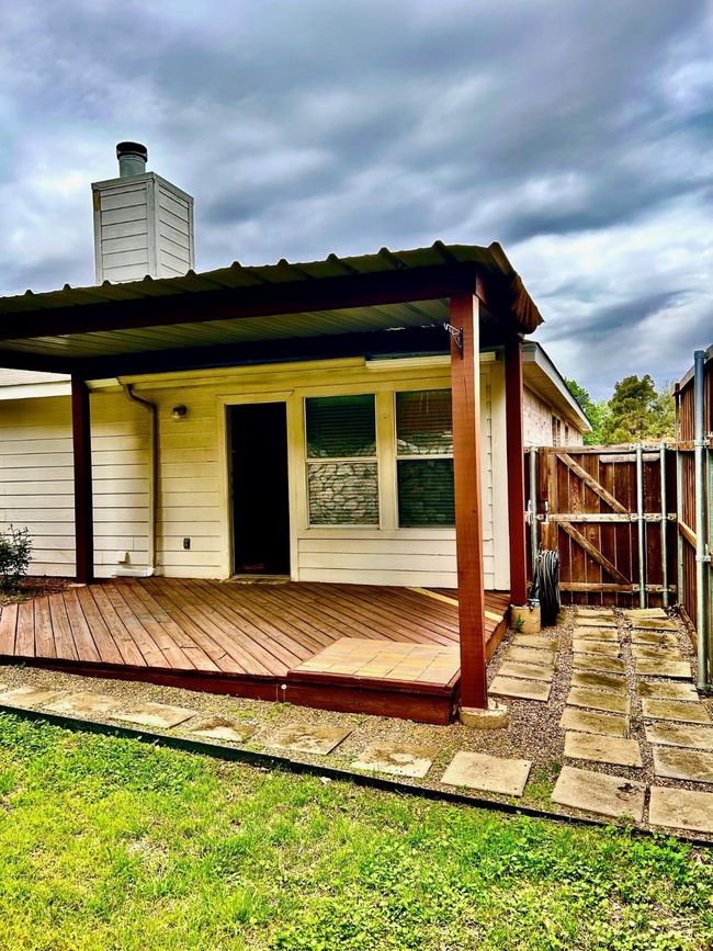 Rear view of property with a wooden deck, a gate, fence, and a chimney | Image 21