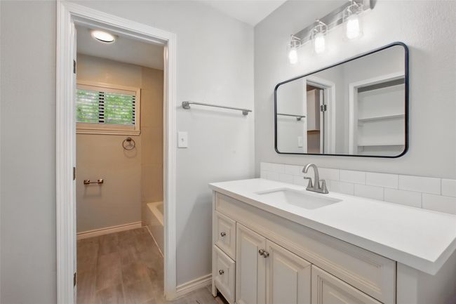 Clean and modern, this bathroom offers updated finishes including sleek tile backsplash and thoughtfully selected designer fixtures. | Image 27