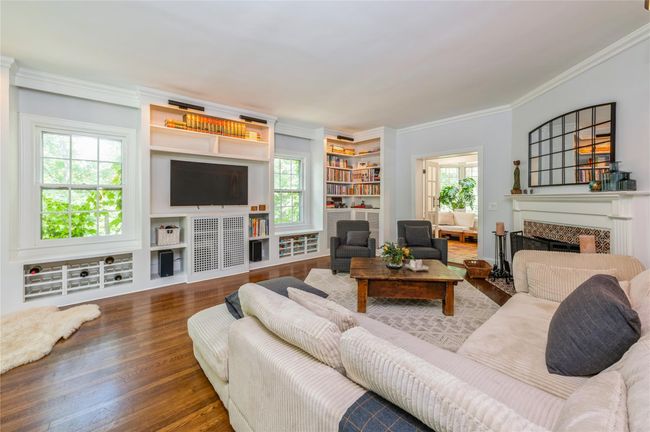 Light filled living room featuring built in cabinetry. | Image 4