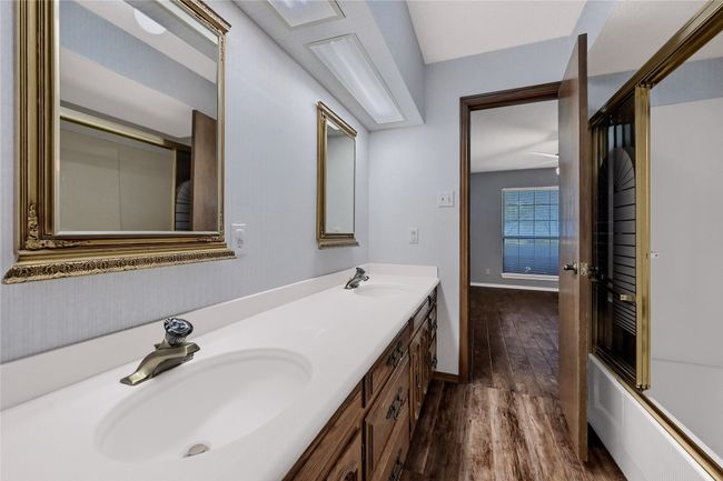 Bathroom with double vanity, baseboards, a sink, and wood finished floors | Image 24