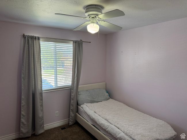 Bedroom with visible vents, dark carpet, and ceiling fan | Image 9