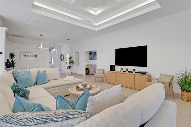 Living room featuring an inviting chandelier, a raised ceiling, and visible vents | Image 8