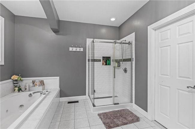 Bathroom featuring a shower stall, a whirlpool tub, tile patterned floors, and baseboards | Image 20