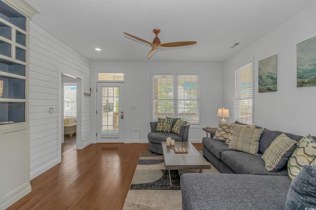 Living area featuring hardwood / wood-style flooring, a ceiling fan, recessed lighting, healthy amount of natural light, and baseboards | Image 7