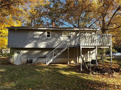 Rear view of property with a yard, a deck, and central AC unit | Image 3