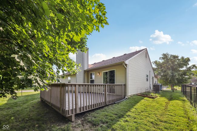 rear view of property featuring a chimney, a wooden deck, and a gate | Image 31