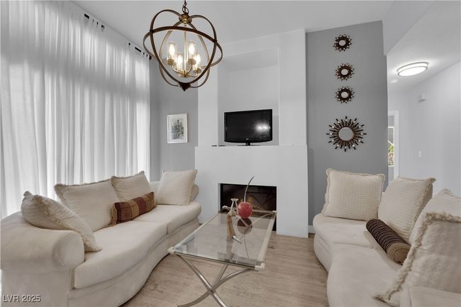 Living room with wood finished floors and a chandelier | Image 7