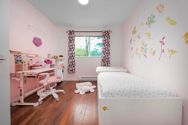 Bedroom with a baseboard radiator, wood finished floors, and baseboards | Image 25