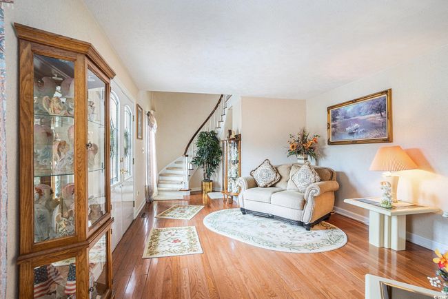 Living room with stairs, wood finished floors, and baseboards | Image 8
