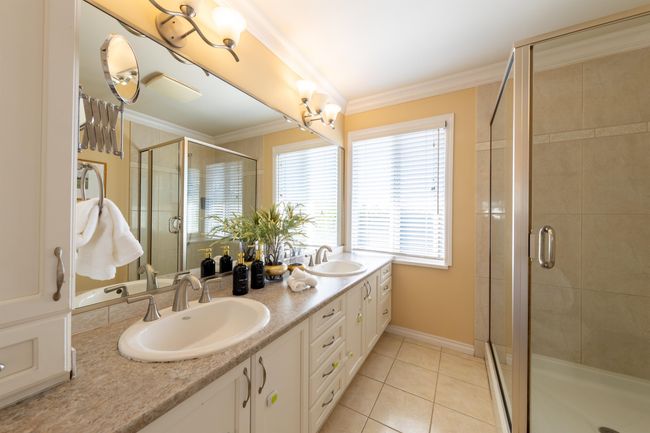Bathroom with tile patterned flooring, a sink, ornamental molding, and a shower stall | Image 26