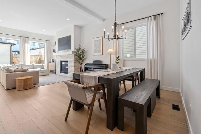 Dining room with an inviting chandelier, beamed ceiling, light wood-style floors, and visible vents | Image 4