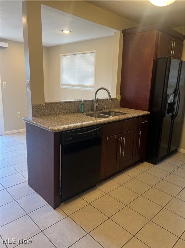 Kitchen featuring light tile floors, sink, dishwasher, and granite countertops | Image 12