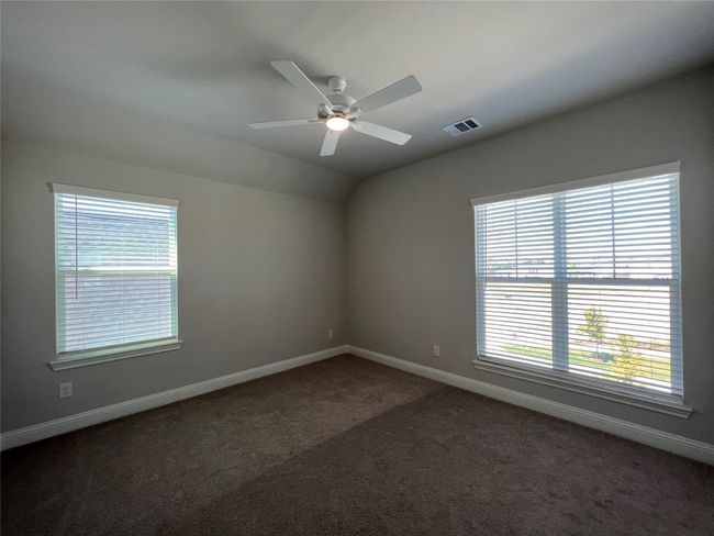 Empty room featuring dark carpet, plenty of natural light, baseboards, ceiling fan, and lofted ceiling | Image 19