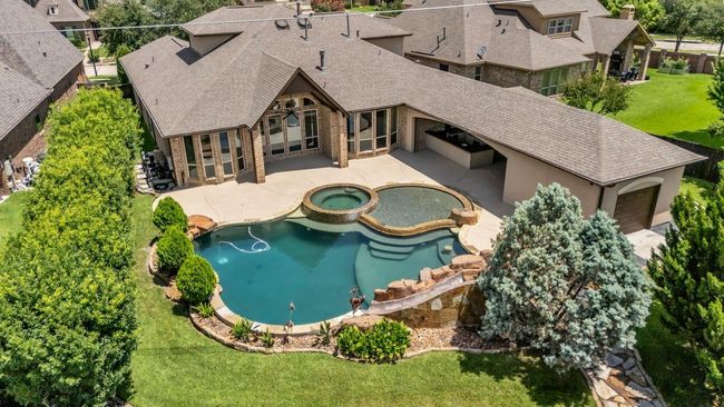 The resort-style pool features a luxurious oversized hot tub, a shallow wading area perfect for lounging, cascading water features, and a thrilling slide that adds a splash of fun | Image 32
