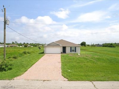 Single story home featuring a garage and a front lawn | Image 1