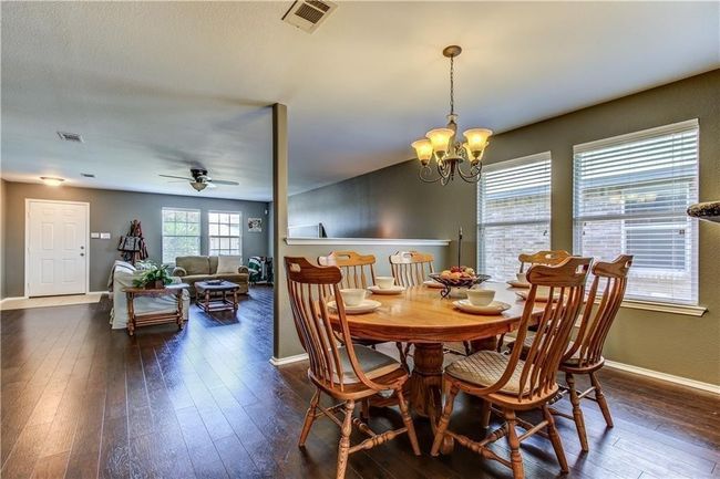 Dining area featuring a chandelier, dark wood-style floors, and ceiling fan | Image 5