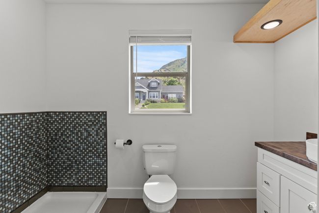 Full bathroom featuring baseboards, vanity, tiled shower, dog wash, tile patterned flooring, and toilet | Image 28