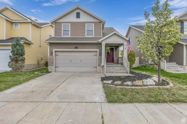 Traditional-style house featuring board and batten siding, an attached garage, and driveway | Image 25