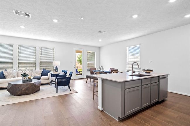 As you enter the Great Room, you take notice of the brightness of this beautiful room. There are beautiful windows with blind, high ceilings, recessed lighting, gorgeous flooring, and this beautiful kitchen island! | Image 10