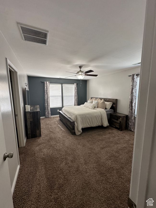 Bedroom with a ceiling fan, carpet flooring, and visible vents | Image 12