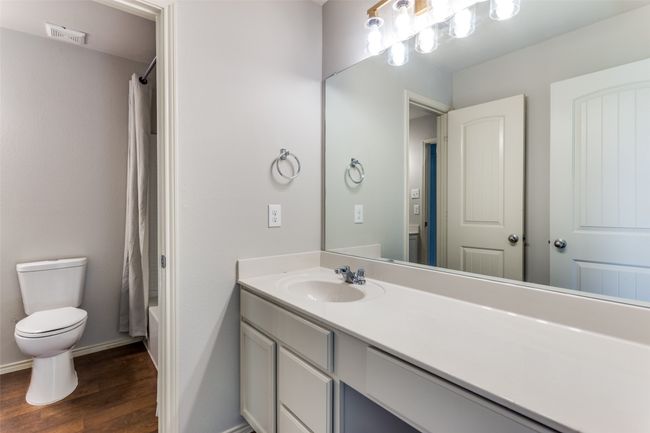 Full bath with wood finished floors, vanity, and shower / bath combo with shower curtain | Image 34