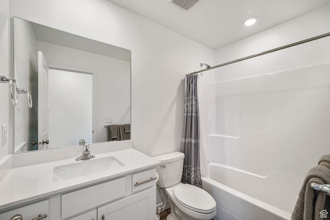 Full bathroom featuring toilet, vanity, and shower / bathtub combination with curtain | Image 25