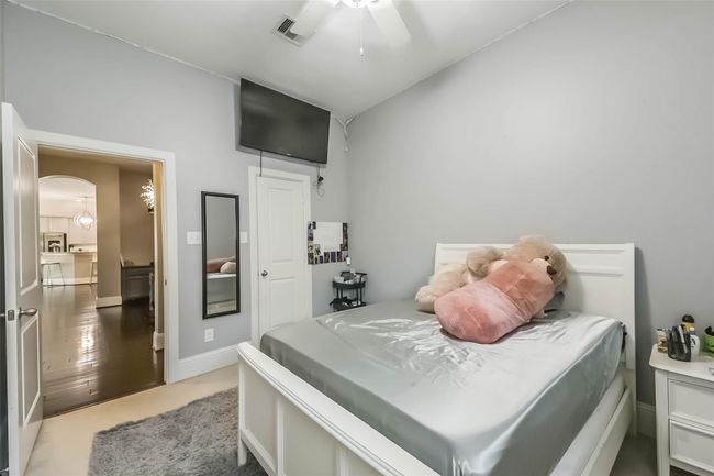 This cozy bedroom features soft gray walls, a ceiling fan, and a plush carpet. | Image 23
