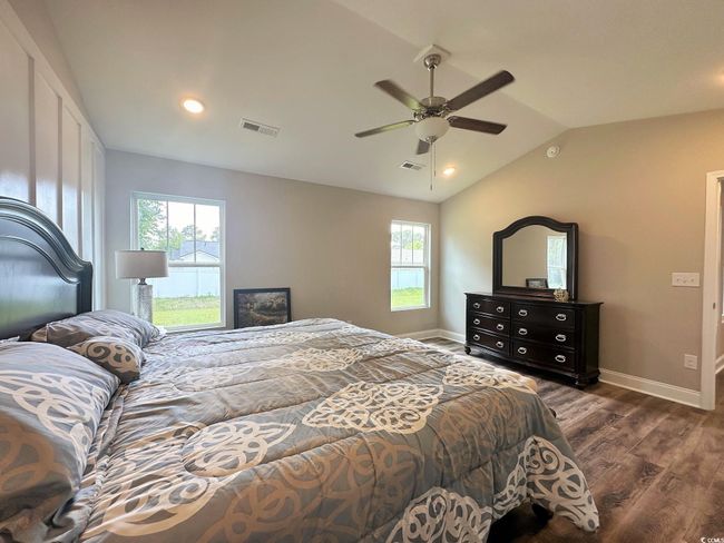 Bedroom featuring dark wood-type flooring, multiple windows, and visible vents | Image 11