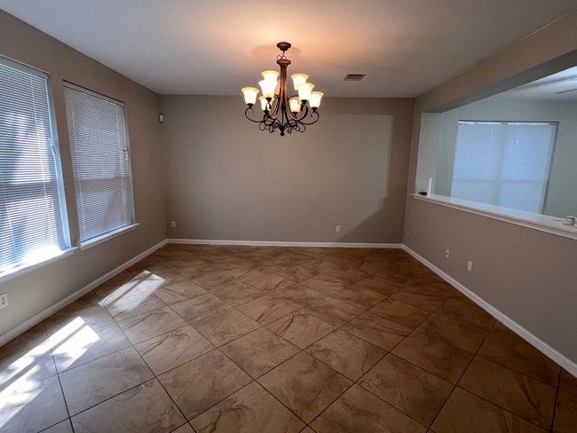 Spare room with a chandelier and baseboards | Image 4