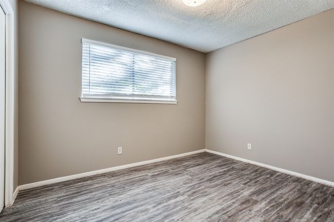 Spare room featuring baseboards, a textured ceiling, and wood finished floors | Image 13