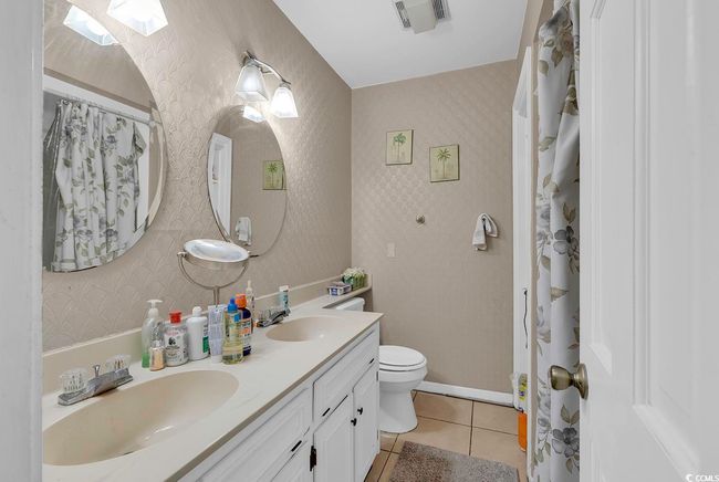 Bathroom featuring wallpapered walls, tile patterned floors, visible vents, and a sink | Image 27