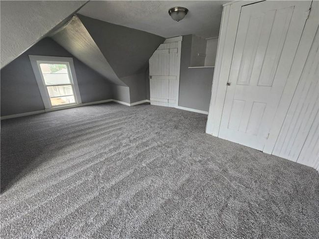 Additional living space with carpet flooring, lofted ceiling, and baseboards | Image 15