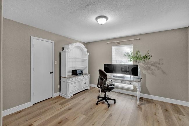 Office space with baseboards, light wood-style floors, and a textured ceiling | Image 22