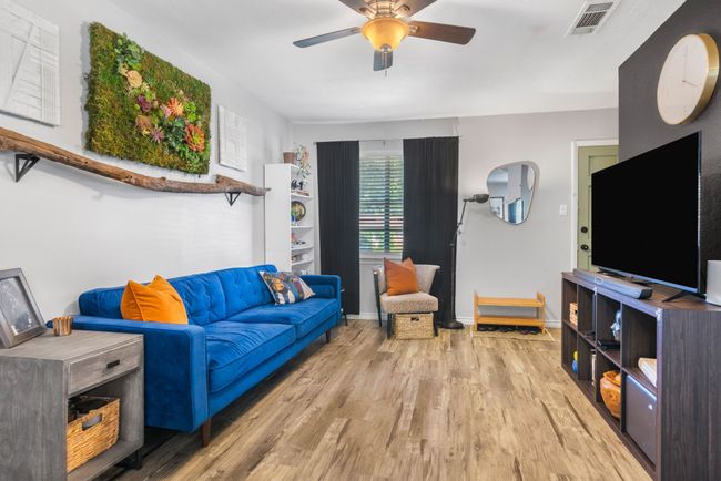 Living area with wood finished floors, ceiling fan, and baseboards | Image 7