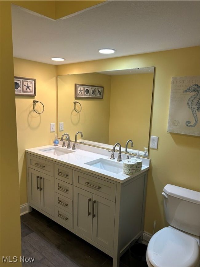 Bathroom featuring a sink, toilet, double vanity, and wood finished floors | Image 8