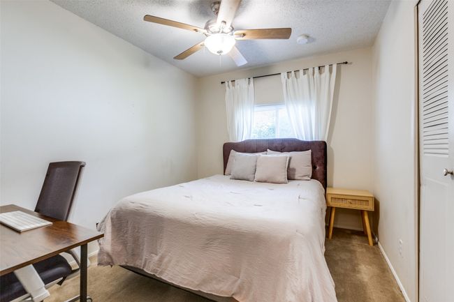Carpeted bedroom featuring a textured ceiling, a ceiling fan, and a closet | Image 8